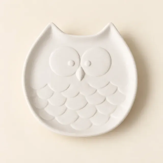 Unpainted white ceramic dish shaped like an owl, with raised eyes and feathers