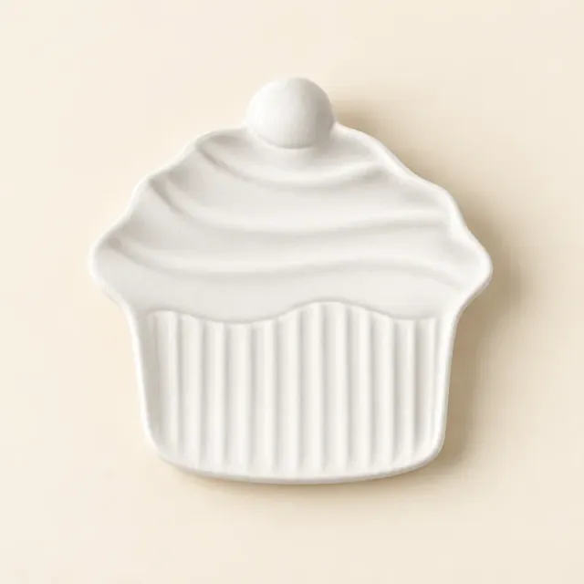 Unpainted white ceramic dish shaped like a cupcake, with a swirled top and ridged case