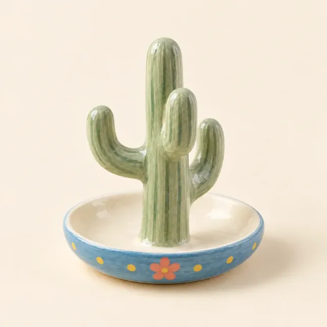 Green cactus ring holder with a blue dish rim, yellow dots and a small pink flower.