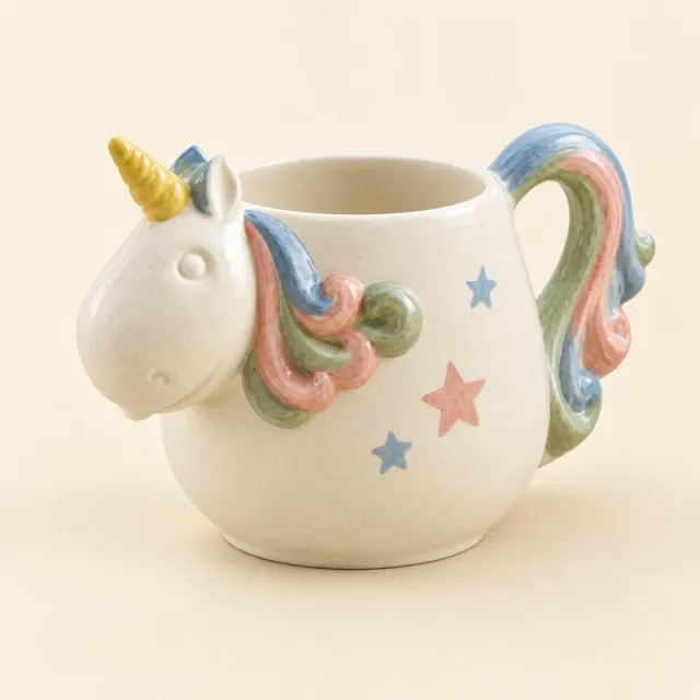 Unicorn mug painted with a blue, pink and green mane, a yellow horn and small stars.